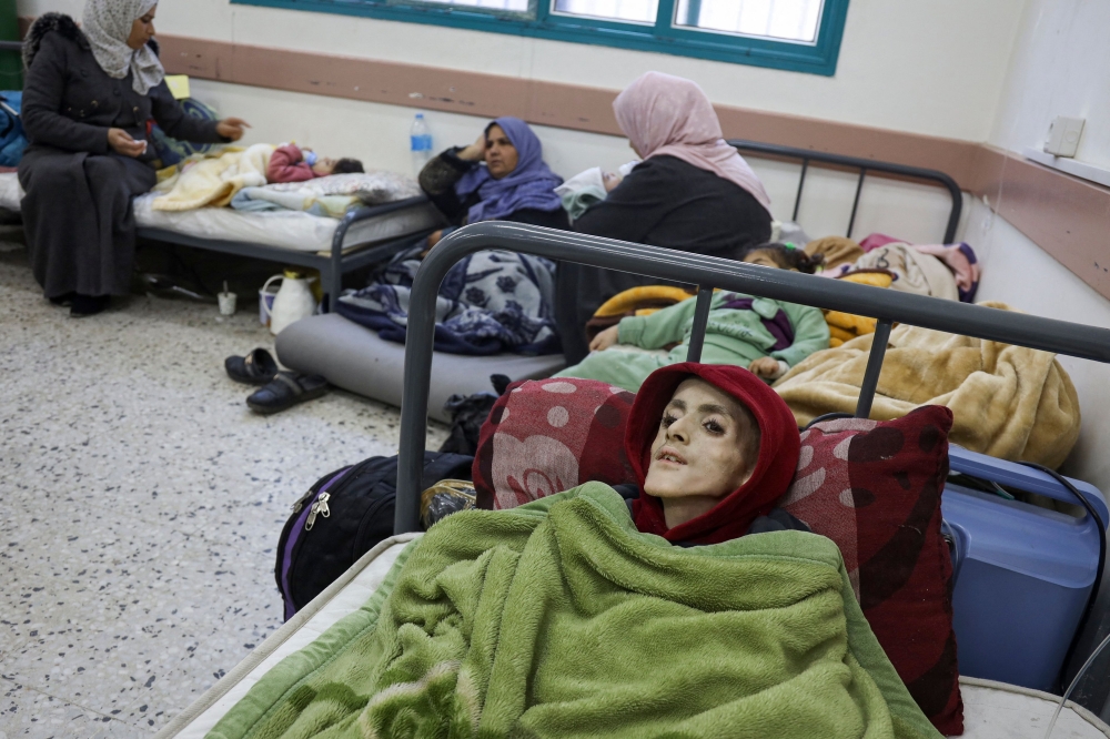 Ten-year-old Palestinian boy, Yazan al-Kafarneh from a pre-existing condition, lies on a hospital bed at Al-Awda clinic in Rafah 