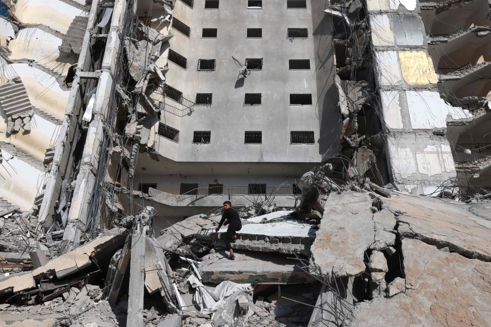 A Palestinian boy inspects the damage to a building hit in an Israeli strike in Rafah, in the southern Gaza Strip. — AFP 