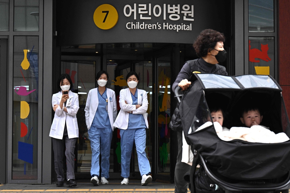 Medical workers walk outside a children hospital in Seoul. — AFP 