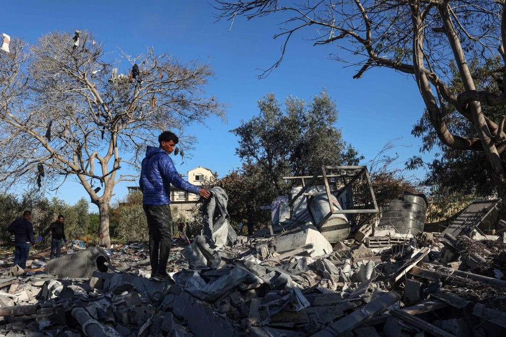A Palestinian searches for his belongings amid the rubble of houses destroyed by Israeli bombardment in Rafah. — AFP 