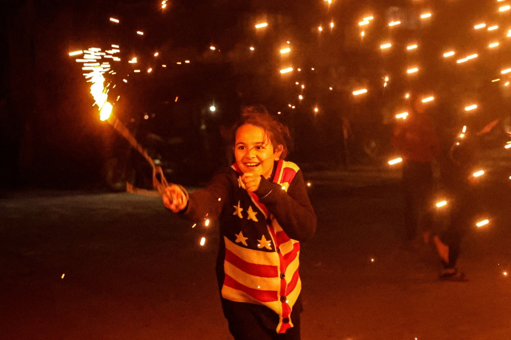 A Palestinian child plays with sparklers in Rafah, in the southern Gaza Strip, on the eve of the holy month of Ramadhan on Monday. - AFP

