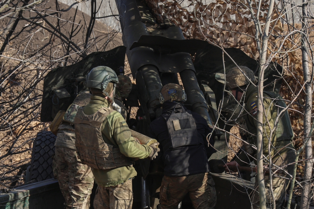 Ukrainian service members prepare a D-20 howitzer before firing toward Russian troops, amid Russia's attack on Ukraine, in Donetsk region, Ukraine
