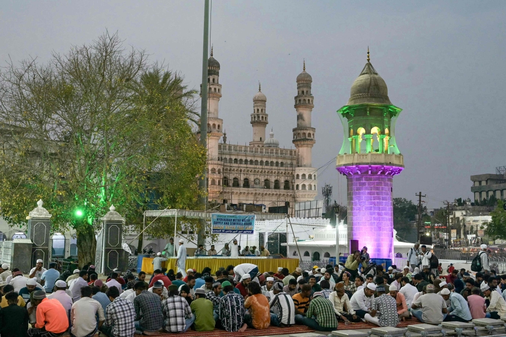 Muslim devotees break their fast on the first day of the Islamic holy month of Ramadan at Mecca Masjid in Hyderabad on March 12, 2024. (Photo by NOAH SEELAM / AFP)

