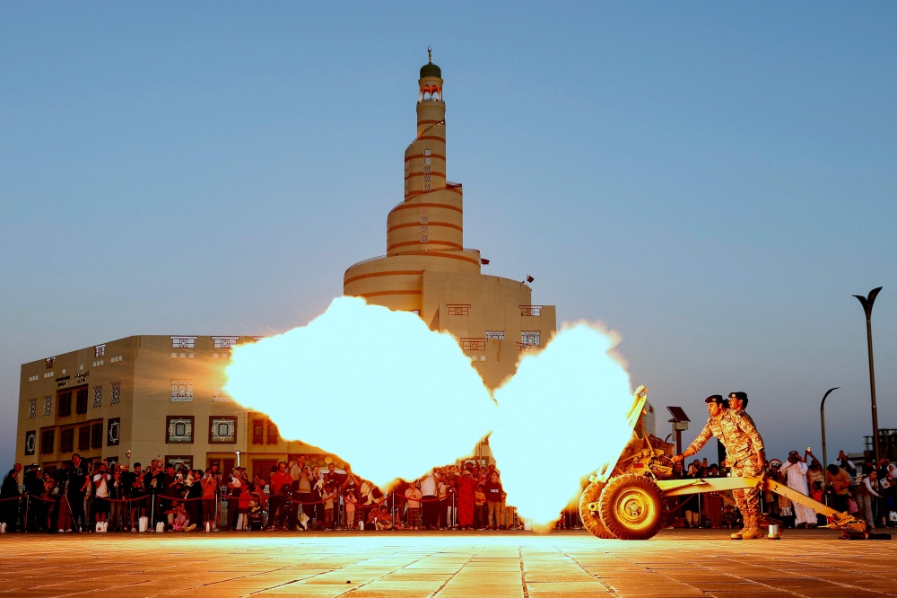 The "iftar" (fast-breaking) cannon is fired to signal sunset and the end of fasting for observing Muslims on the second day of Islam's holy month of Ramadan at Souq Waqif Traditional Market in Doha on March 12, 2024.  (Photo by KARIM JAAFAR / AFP)

