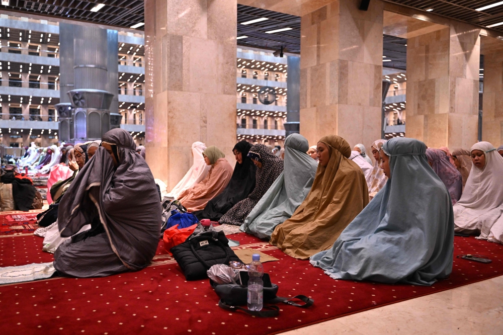 Muslim people offer night prayers on the second night of the holy month of Ramadan at the Istiqlal mosque in Jakarta on March 12, 2024. (Photo by ADEK BERRY / AFP)

