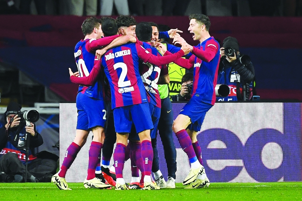Barcelona players celebrate their third goal.— AFP

