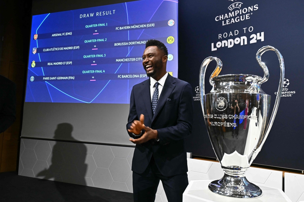 Former Nigerian footballer John Obi Mikel poses next to the trophy after performing the 2023-2024 UEFA Champions League draw