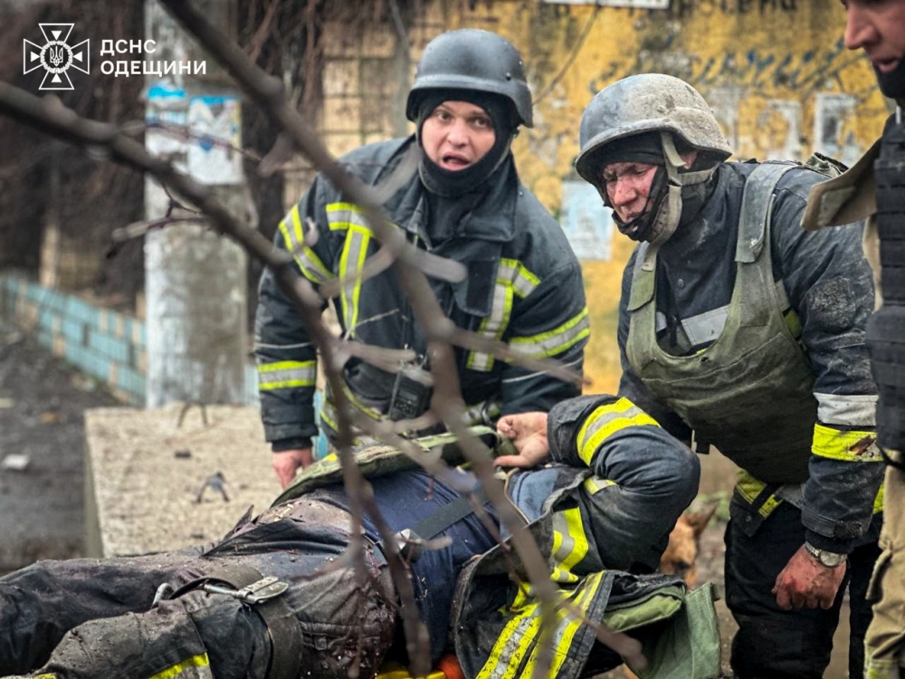 Rescuers carry an injured colleague at the site of a Russian missile strike, amid Russia's attack on Ukraine