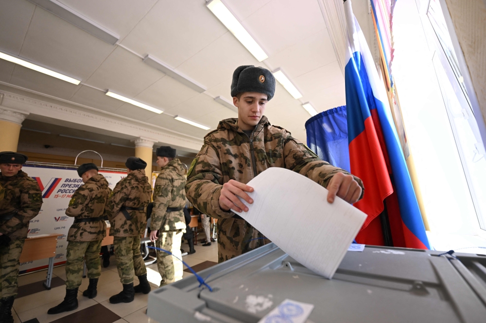 A service member casts his ballot in Russia's presidential election in Moscow