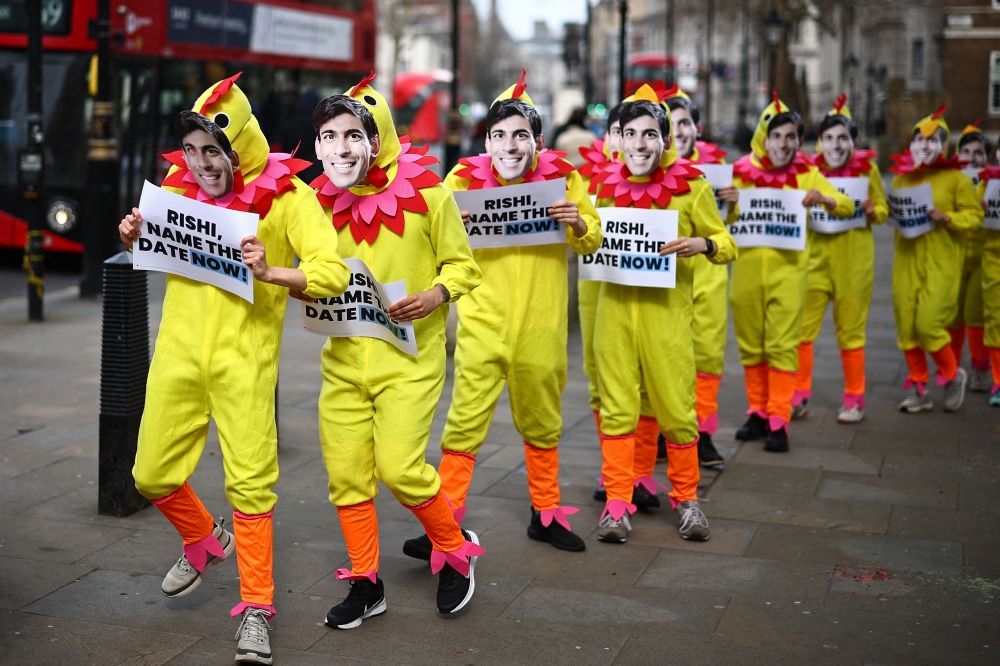 Activists from Britain's main opposition Labour Party pose for a photograph dressed in chicken suits wearing masks of Britain's Prime Minister Rishi Sunak, to encourage him to call a General Election, in central London