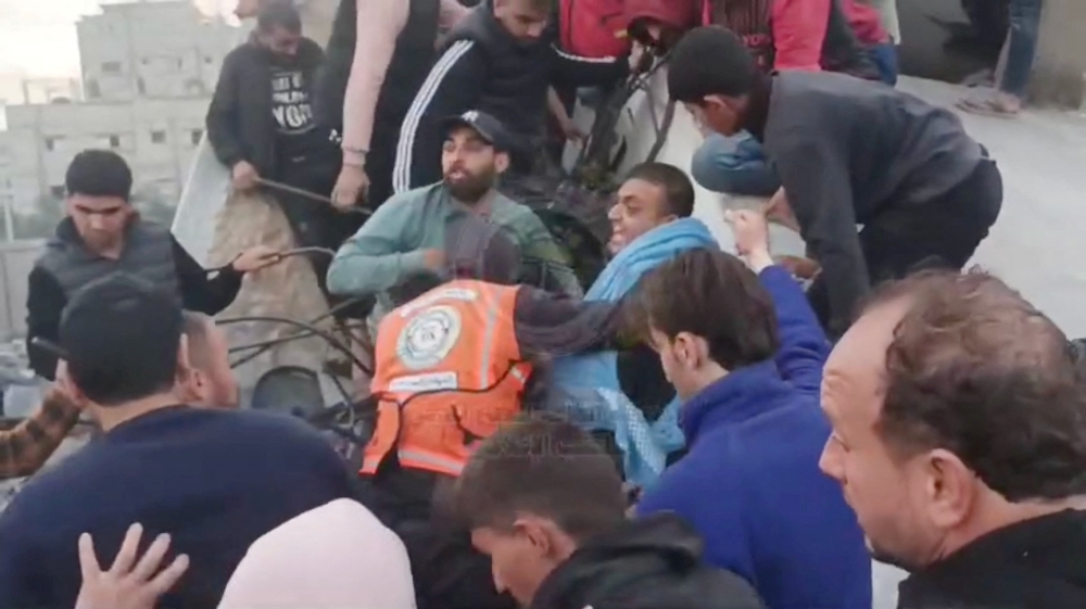 A rescue worker along with people look for survivors under the rubble
