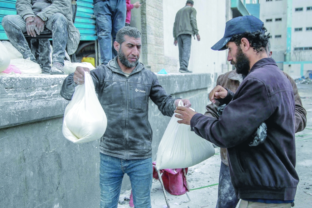 A man receives a bag of flour during the distribution of humanitarian aid in Gaza City. — AFP 