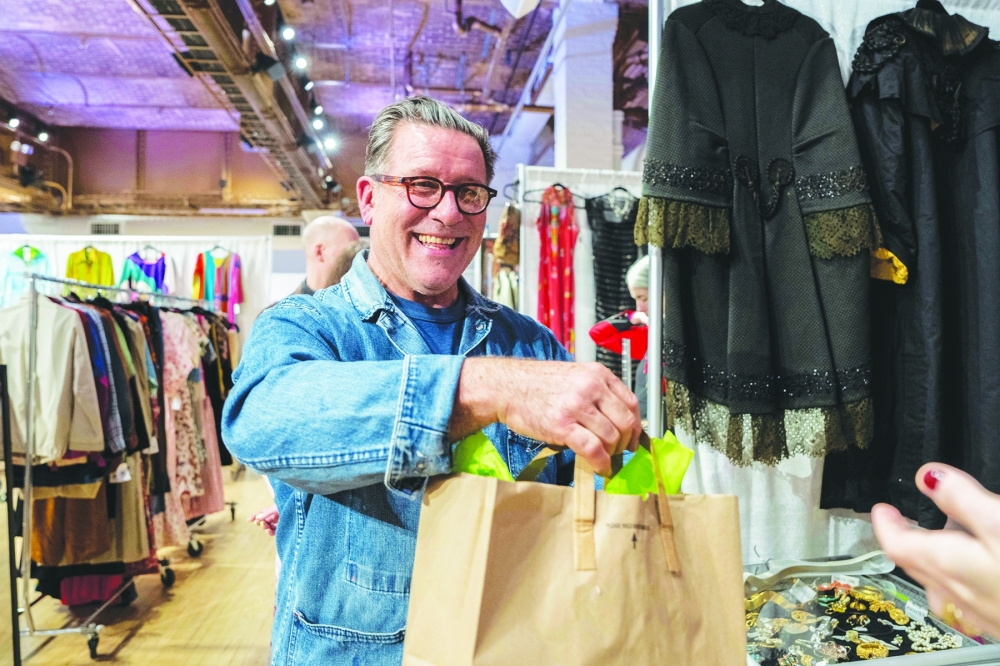 David Brockman, owner and producer of the Sturbridge Show since 2022, helps a seller bag a purchase at the Sturbridge Vintage Show in New York, March 14, 2024. (Hiroko Masuike/The New York Times)