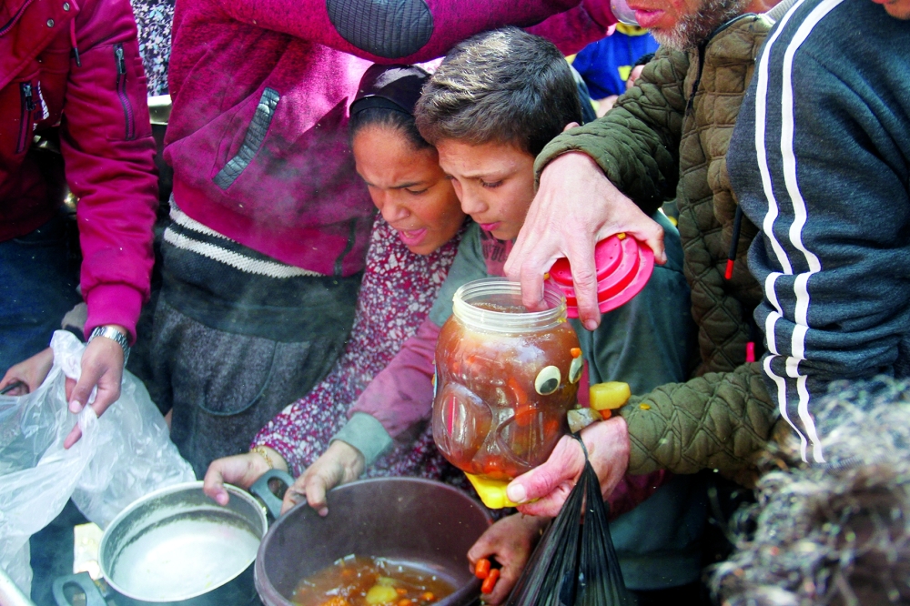 Palestinians gather to receive food as Gaza residents face crisis levels of hunger, in Jabalia. — Reuters 
