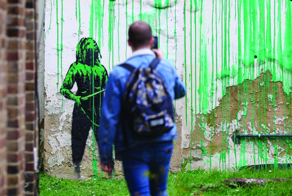 A person views a new mural attributed to the British artist Banksy on a wall in north London, Britain, March 18, 2024. REUTERS/Toby Melville