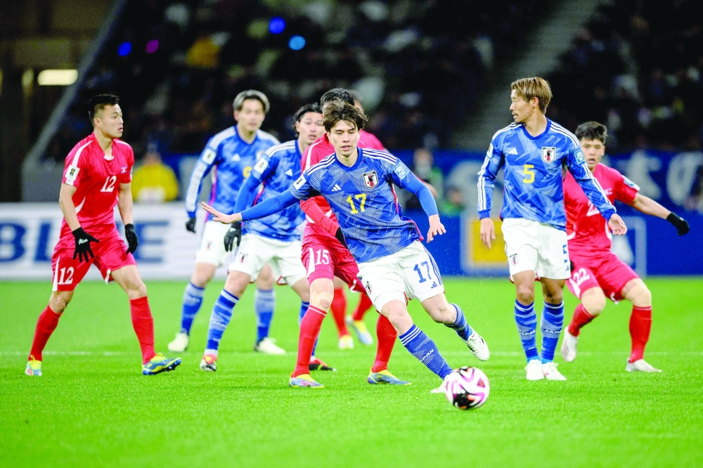 Japan's Ao Tanaka (C) controls the ball during their World Cup 2026 qualifier football match between Japan and North Korea at the National Stadium in Tokyo on March 21, 2024. (Photo by Philip FONG / AFP)