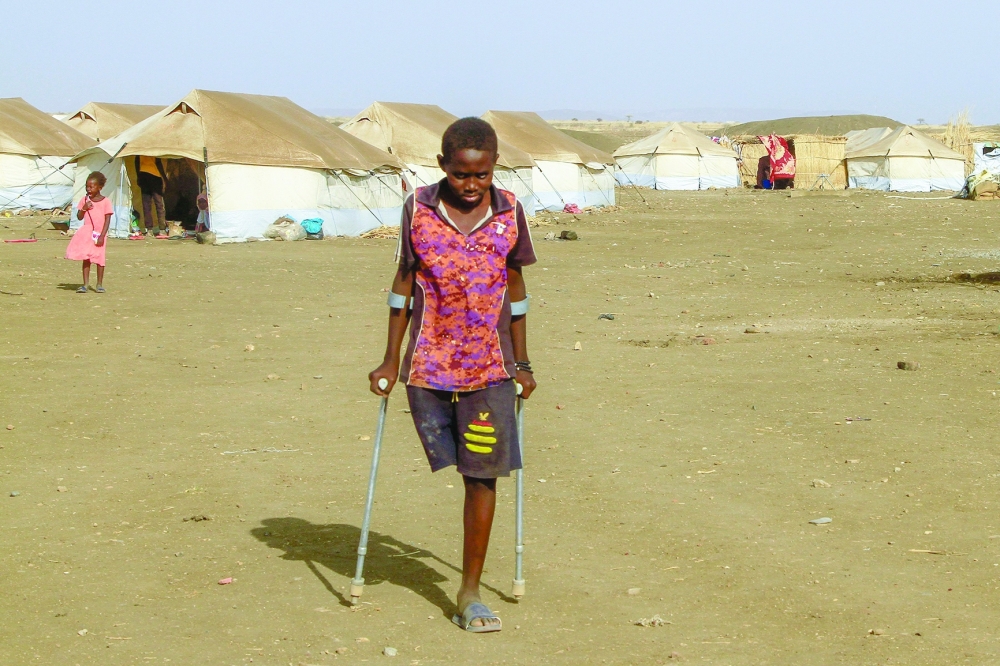 A picture shows children who fled Khartoum and Jazira states in war-torn Sudan standing near tents at a camp for the internally displaced in southern Gadaref state. - AFP