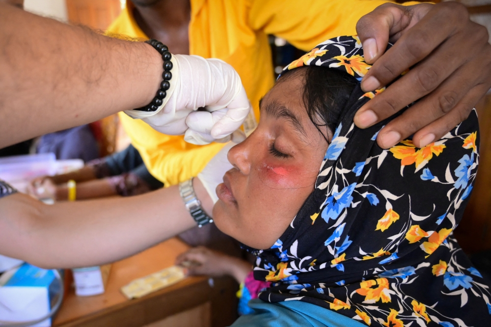 A newly arrived Rohingya refugee receives medical treatment at their shelter in Meulaboh