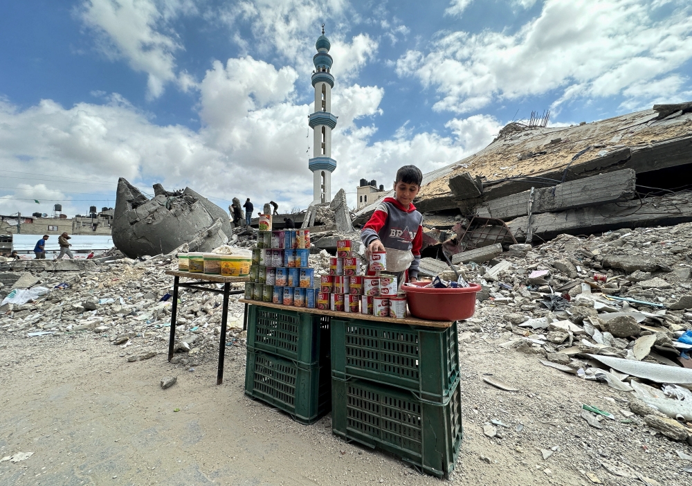 A boy stands next to canned food on the day of Friday prayers during Ramadhan, amid the ongoing conflict between Israel and Hamas