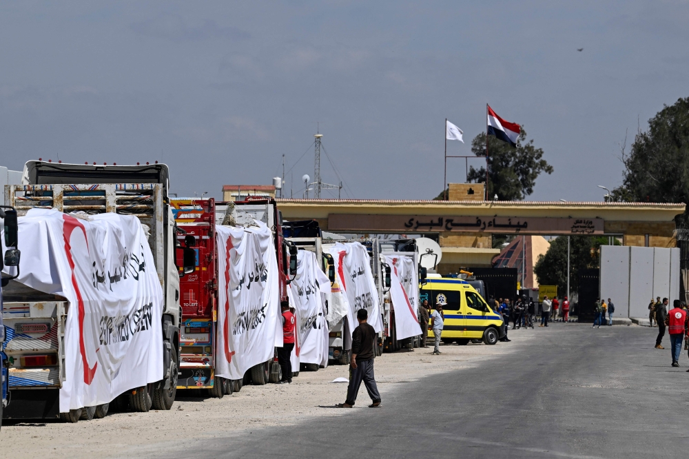 Egyptian Red Crescent trucks loaded with aid queue outside the Rafah border crossing with the Palestinian Gaza Strip. — AFP 