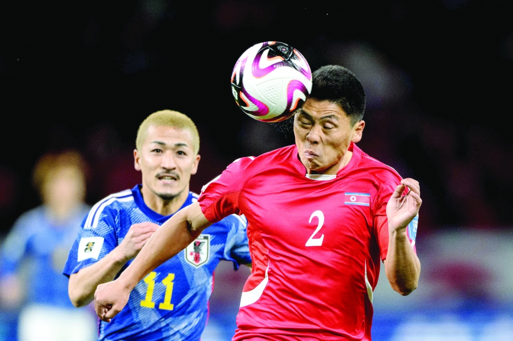 North Korea's defender Kim Kyong Sok and Japan's Daizen Maeda (L) compete for the ball during the World Cup 2026 qualifier football match between Japan and North Korea at the National Stadium in Tokyo on March 21, 2024. (Photo by Philip FONG / AFP)

