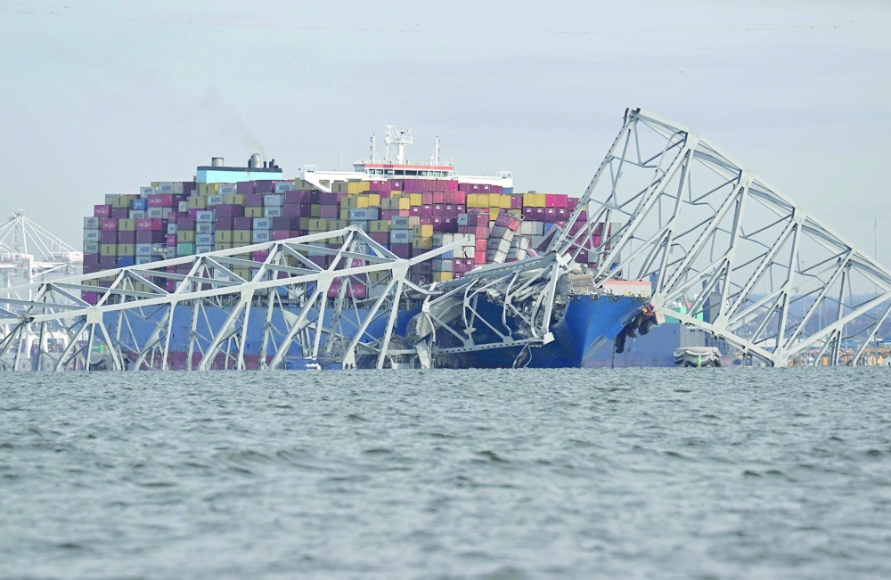 The steel frame of the Francis Scott Key Bridge sits on top of a container ship after the bridge collapsed in Baltimore. — AFP 