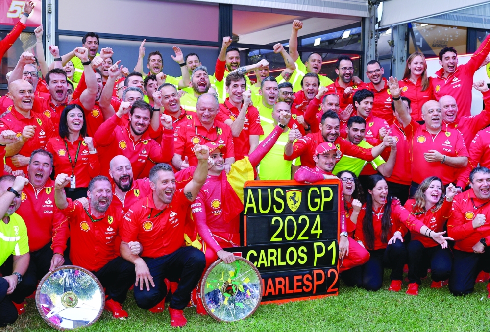 Formula One F1 - Australian Grand Prix - Melbourne Grand Prix Circuit, Melbourne, Australia - March 24, 2024 Ferrari's Carlos Sainz Jr. celebrates with his team after winning the Australian Grand Prix along with second placed Ferrari's Charles Leclerc and team principal Frederic Vasseur REUTERS/Mark Peterson