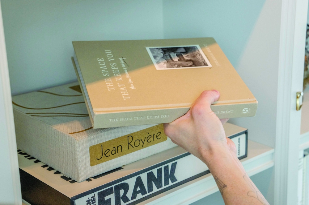 Interior designer Jeremiah Brent arranges a bookshelf at his home in New York on March 4, 2024.