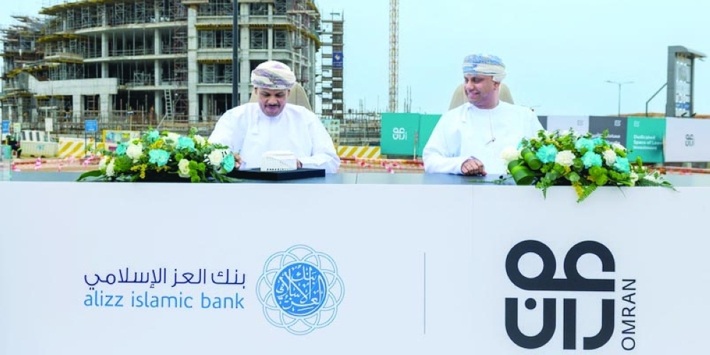 Dr Hashil bin Obaid al Mahrouqi, CEO of Omran Group and Ali bin Saif al Mani, CEO of Alizz Islamic Bank, sign the agreement.