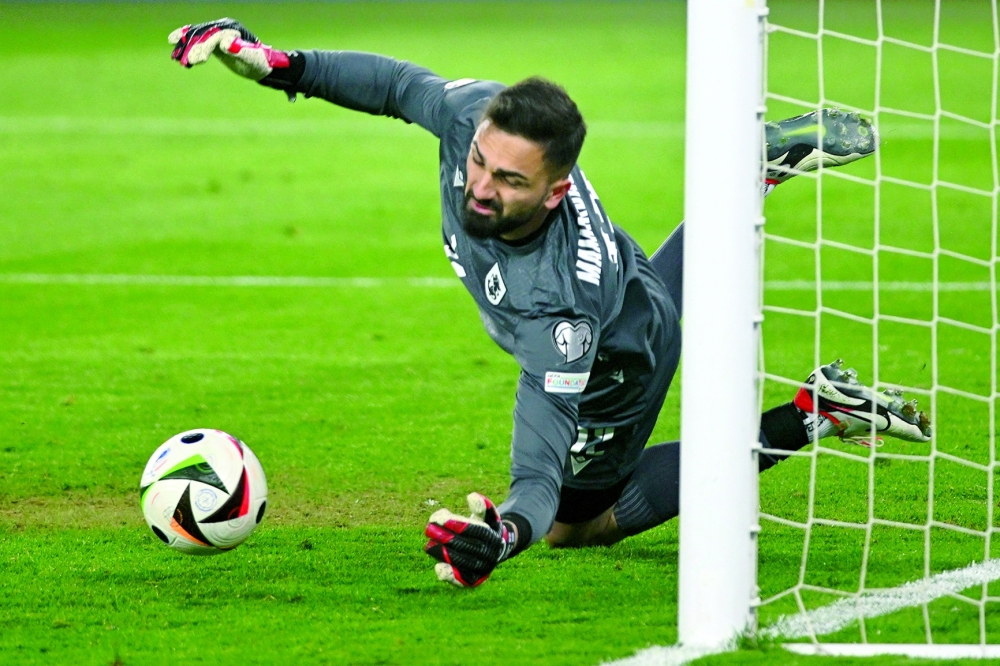 Georgia's goalkeeper #12 Giorgi Mamardashvili saves a penalty in the penalty shoot-out during the UEFA EURO 2024 qualifying play-off final football match between Georgia and Greece in Tbilisi on March 26, 2024. (Photo by Vano SHLAMOV / AFP)

