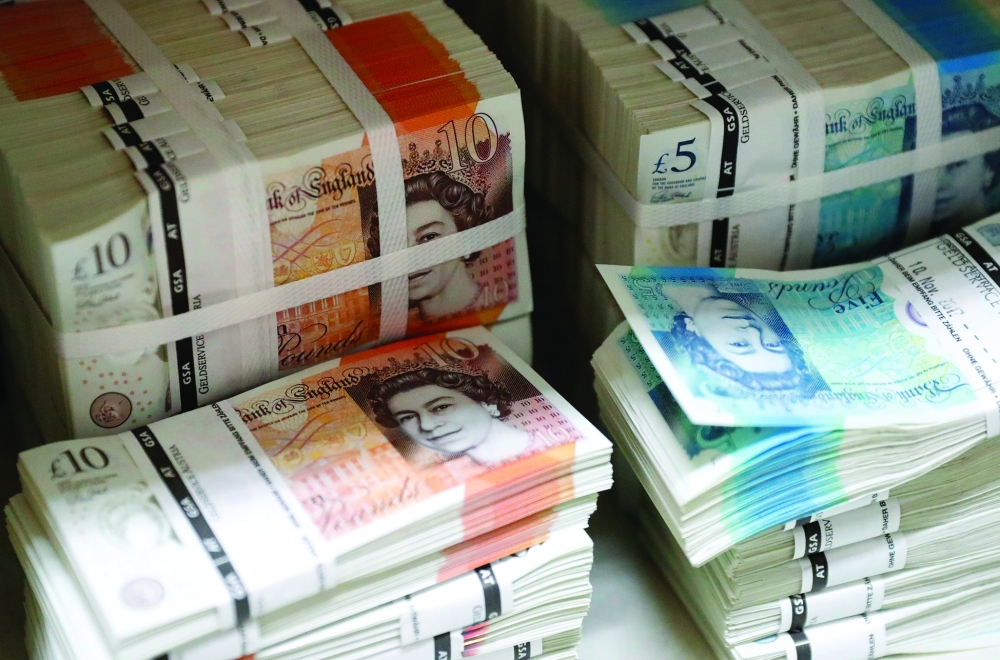 Piles of British Pound Sterling banknotes are stacked in the image. — Reuters