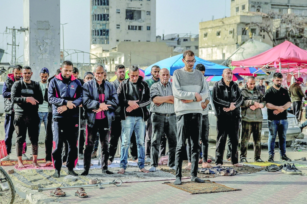 Muslim worshippers perform the "Asr" (afternoon) prayers near an open-air market in Gaza City on March 27, 2024 amid the ongoing conflict in the Gaza Strip between Israel and the Palestinian militant group Hamas. 
