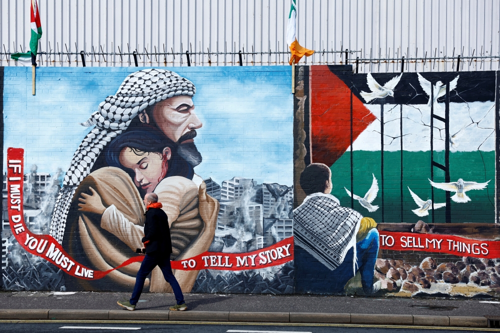 A man walks past pro-Palestinian murals on the International Wall in support of Gaza, in Belfast, Northern Ireland. — Reuters 