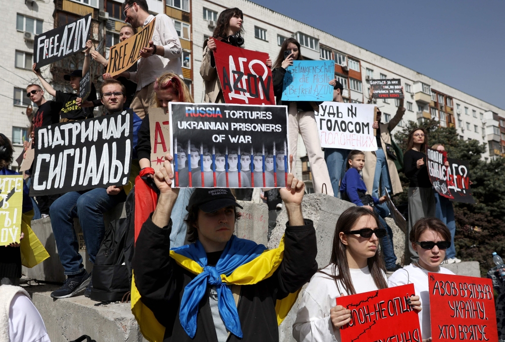 Relatives and friends of Ukrainian prisoners of war from the Azov Brigade and sub-units hold placards during a rally in the center of Kyiv. — AFP 