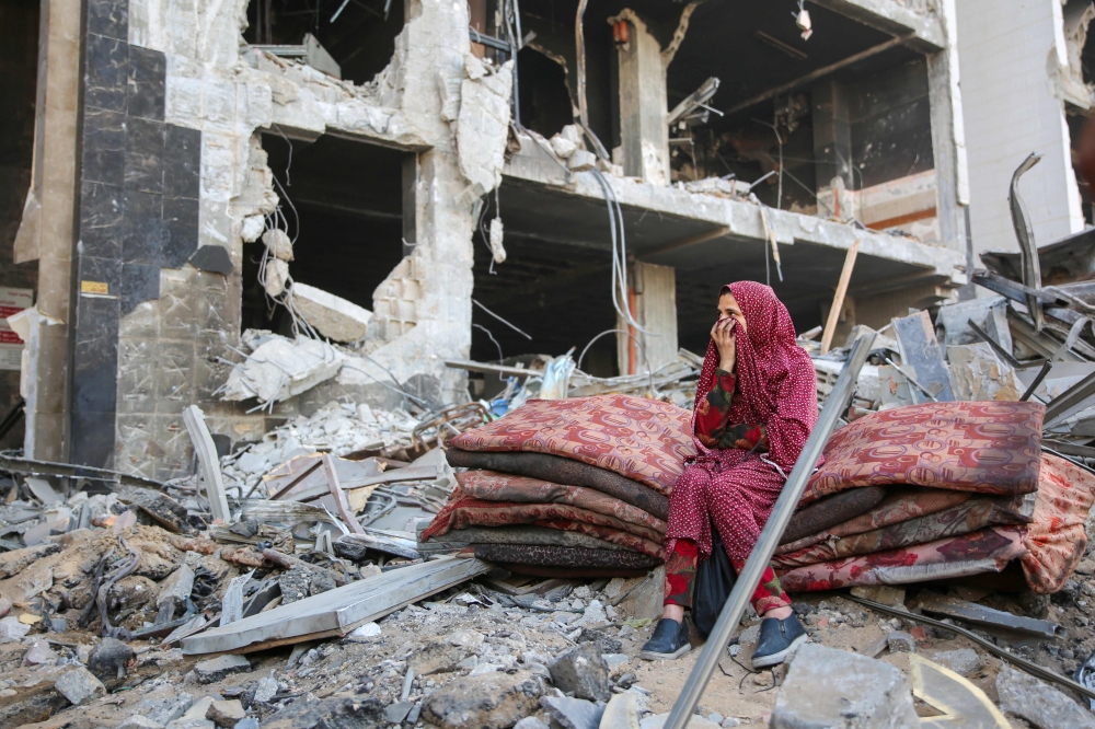 A Palestinian woman reacts as she sits amidst the rubble of Gaza's Al-Shifa hospital after the Israeli military withdrew from the complex housing the hospital on April 1, 2024, amid the ongoing battles Israel and the Hamas militant group.  (Photo by AFP)

