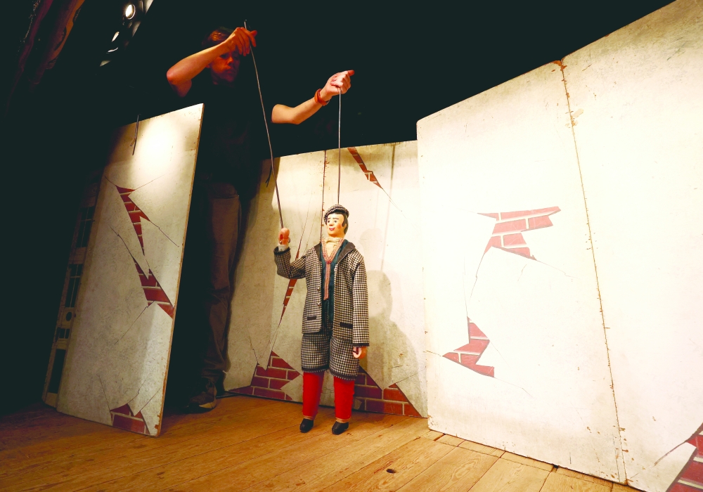 Belgian puppetmaster Guillaume Hoedt operates a puppet called "Woltje" at the Royal Toone Theatre, in Brussels, Belgium, March 28, 2024.