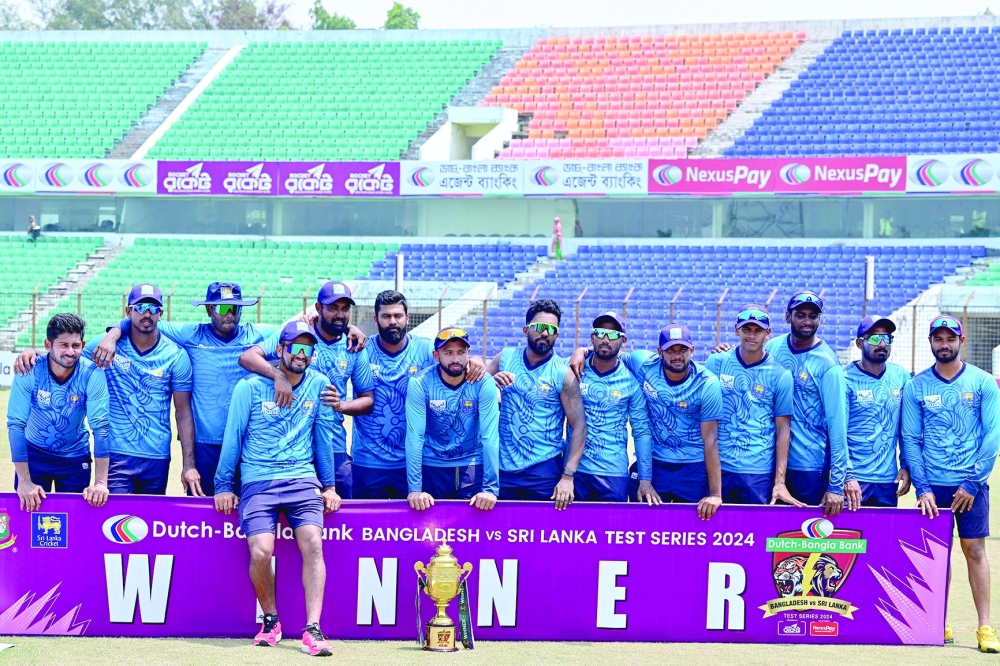 Sri Lanka's players pose with the series trophy after winning the second and last Test cricket match between Bangladesh and Sri Lanka at the Zahur Ahmed Chowdhury Stadium in Chittagong on April 3, 2024. (Photo by MUNIR UZ ZAMAN / AFP)

