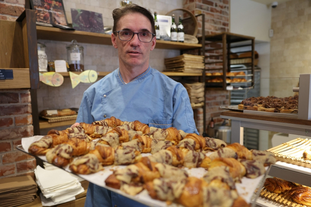 French pastry chef Stephane Louvard poses with his “Crookies”, traditional French croissants mixed with cookie dough, in his pastry shop in Paris 