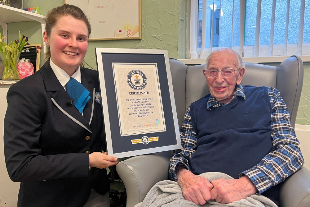 John Tinniswood, 111, poses with his certificate from the Guinness World Records, who announced that he is the world's oldest living man