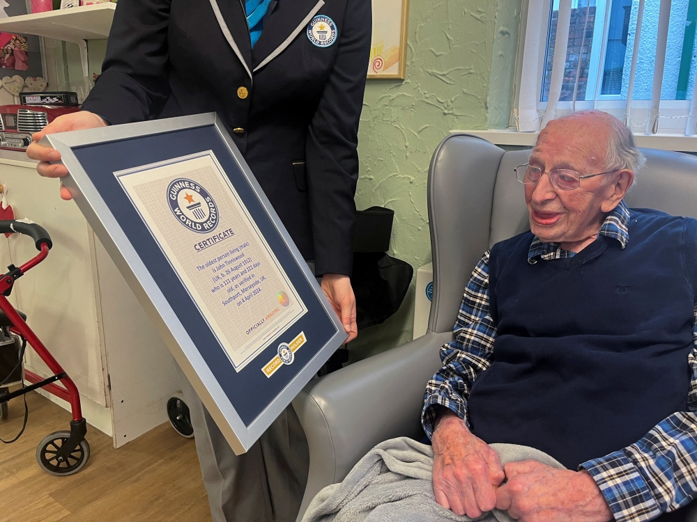 John Tinniswood, 111, poses with his certificate from the Guinness World Records