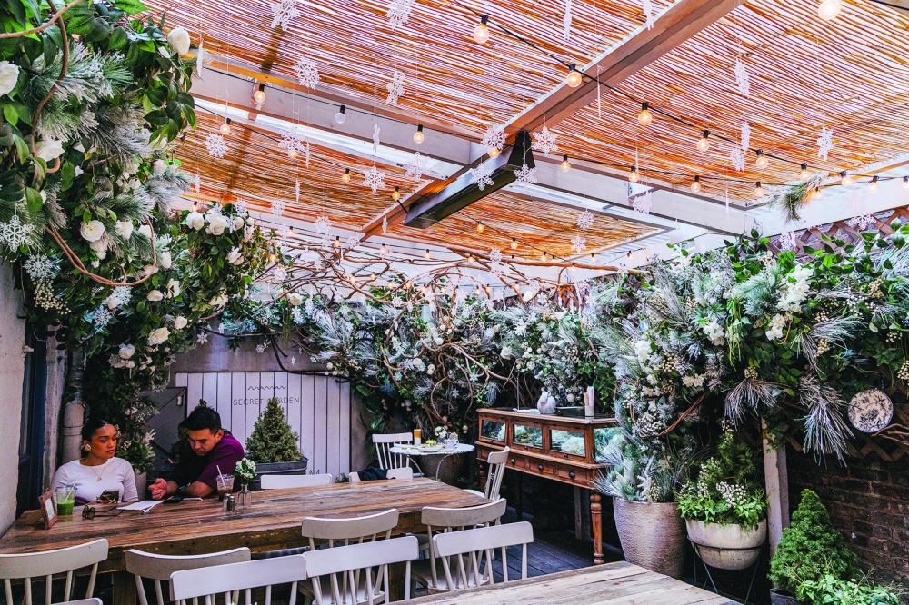 An elaborate faux flower installation above the dining room at an outpost of the French cafe chain Maman in New York on March 14, 2024. 