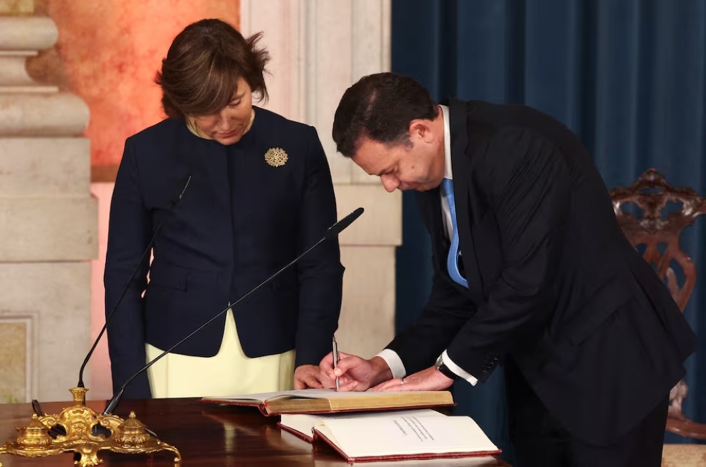 Portuguese Prime Minister Luis Montenegro signs the protocol during the swearing-in ceremony of the new government, at Ajuda Palace in Lisbon. - Reuters 