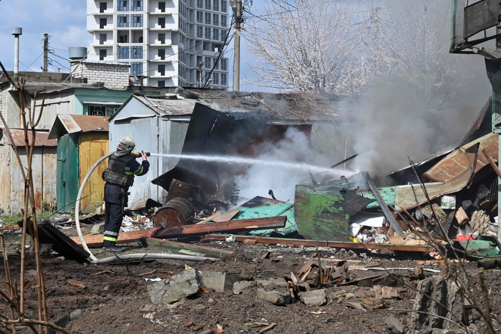 A firefighter extinguishes a fire at the site of a missile strike in the center of Kharkiv, Ukraine. — AFP 
