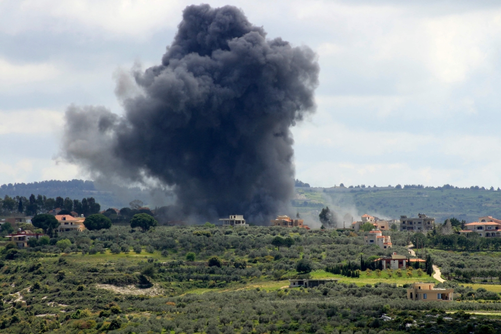  Smoke billows after an Israeli strike on the southern Lebanese border village of Tayr Harfa. — AFP 