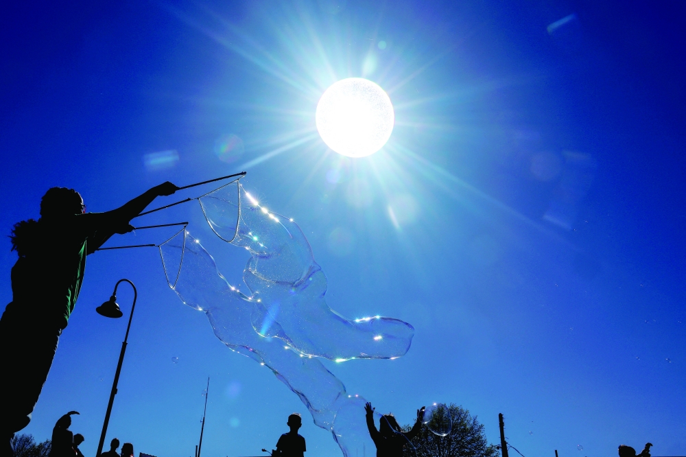 A giant bubble passes in front of the sun as people play with bubbles at the Carbondale Spring Fest ahead of the total solar eclipse in Carbondale, Illinois, US, on Sunday. — Reuters