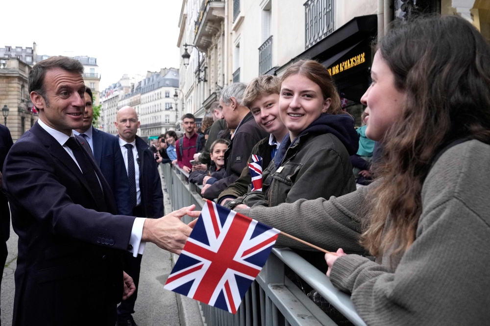 French President Emmanuel Macron shakes hands with onlookers gathered outside the Elysee Palace, in Paris. — AFP 