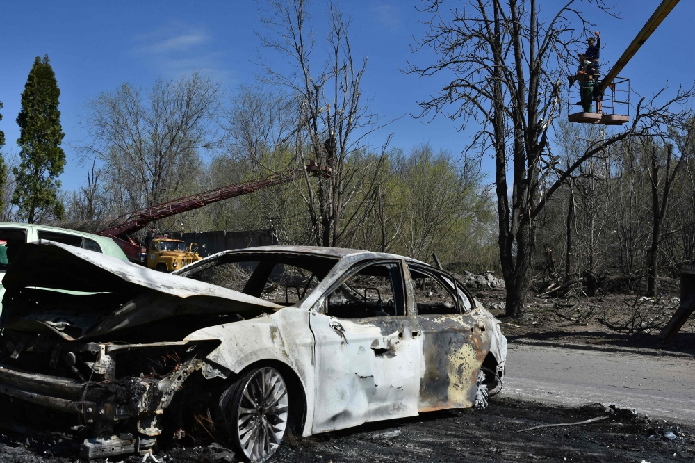 Workers repair power line in Zaporizhzhia after night shelling on April 6. — AFP 