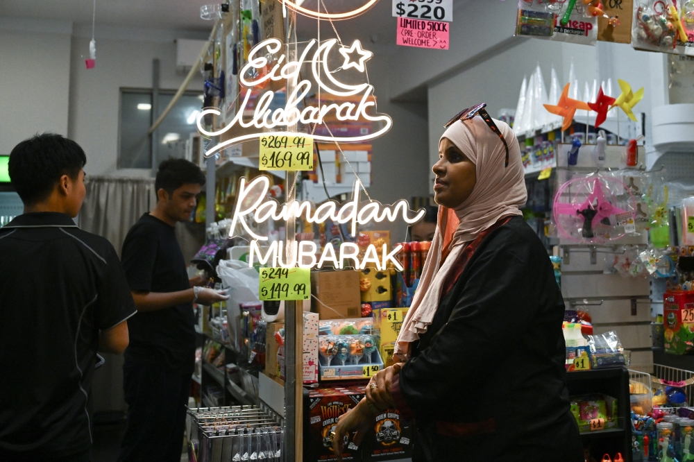  A woman shops during Eid al Fitr, marking the end of the holy month of Ramadhan in the suburb of Lakemba in Sydney, Australia, on Tuesday. — Reuters
