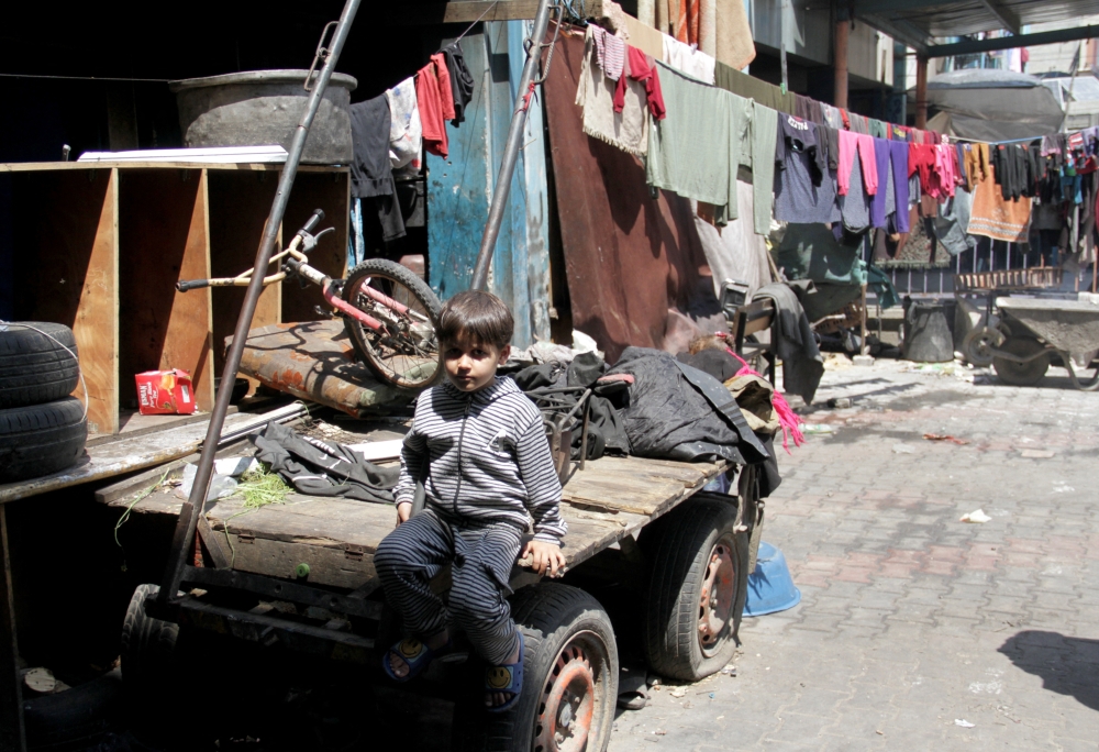 A child sits on a cart as Palestinians prepare for the upcoming holiday of Eid al-Fitr, in northern Gaza Strip. — Reuters 