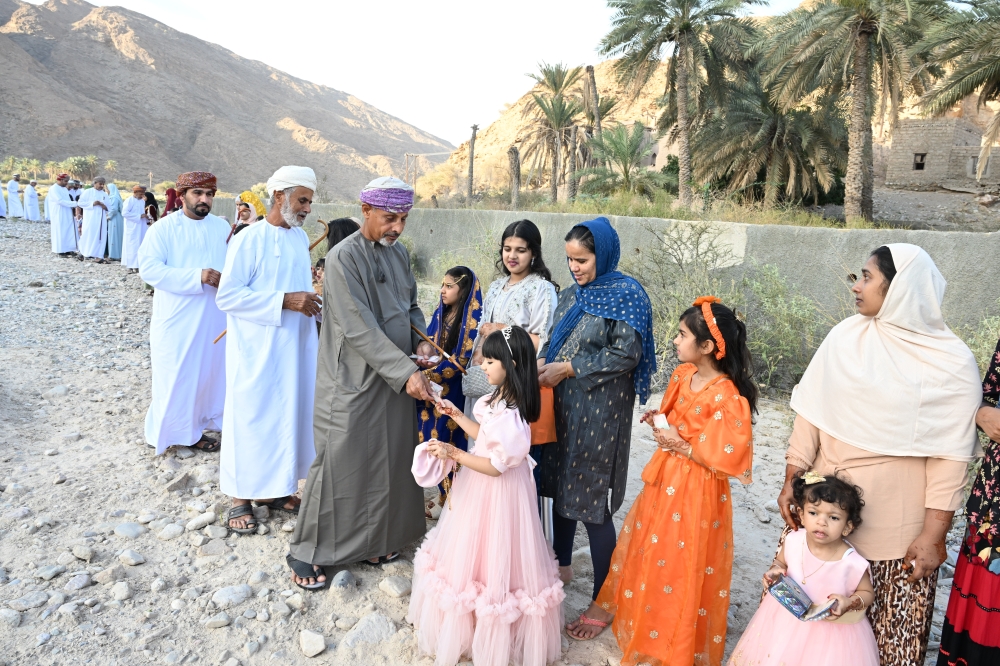 Elders exchange Eidia with children in Al Amerat on Wednesday. Photo by Khalfan al Ruzaiqi